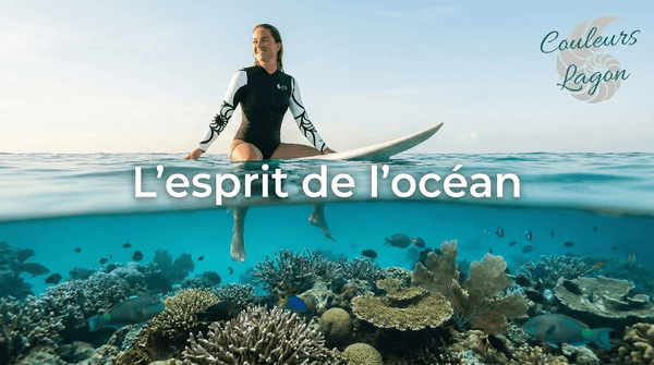 Combinaison surf pour femme UPF50+ Couleurs Lagon — surfeuse assise sur sa planche au-dessus du récif corallien du lagon de Nouvelle-Calédonie