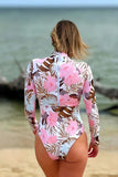 Dos de la combi surf femme manches longues rose floral UPF50+ avec zip dos, portée par Élodie sur la plage